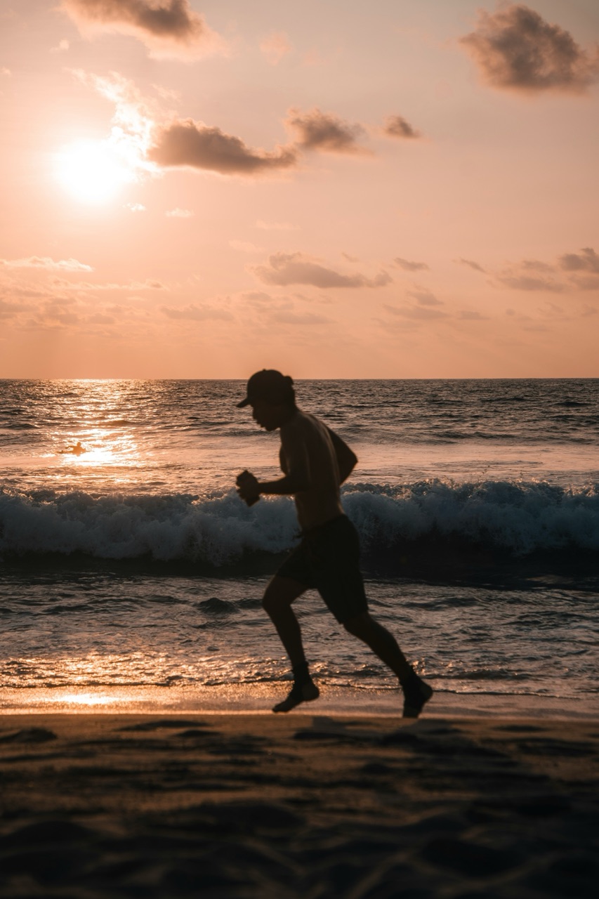 A runner on the beach at sunset